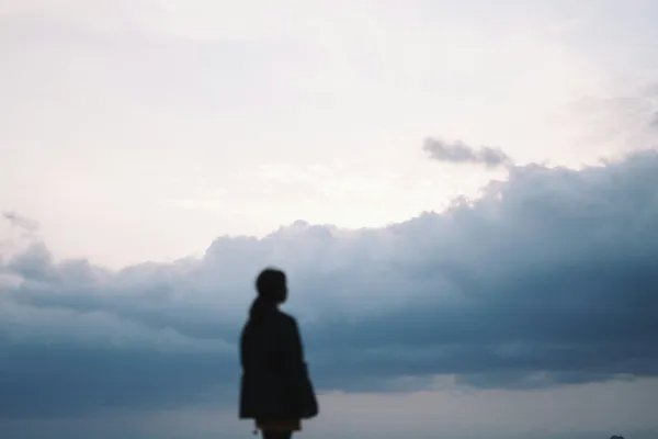 Quelle: Seungjun Yeo/Unsplash Silhouette einer Frau vor dunklen Wolken