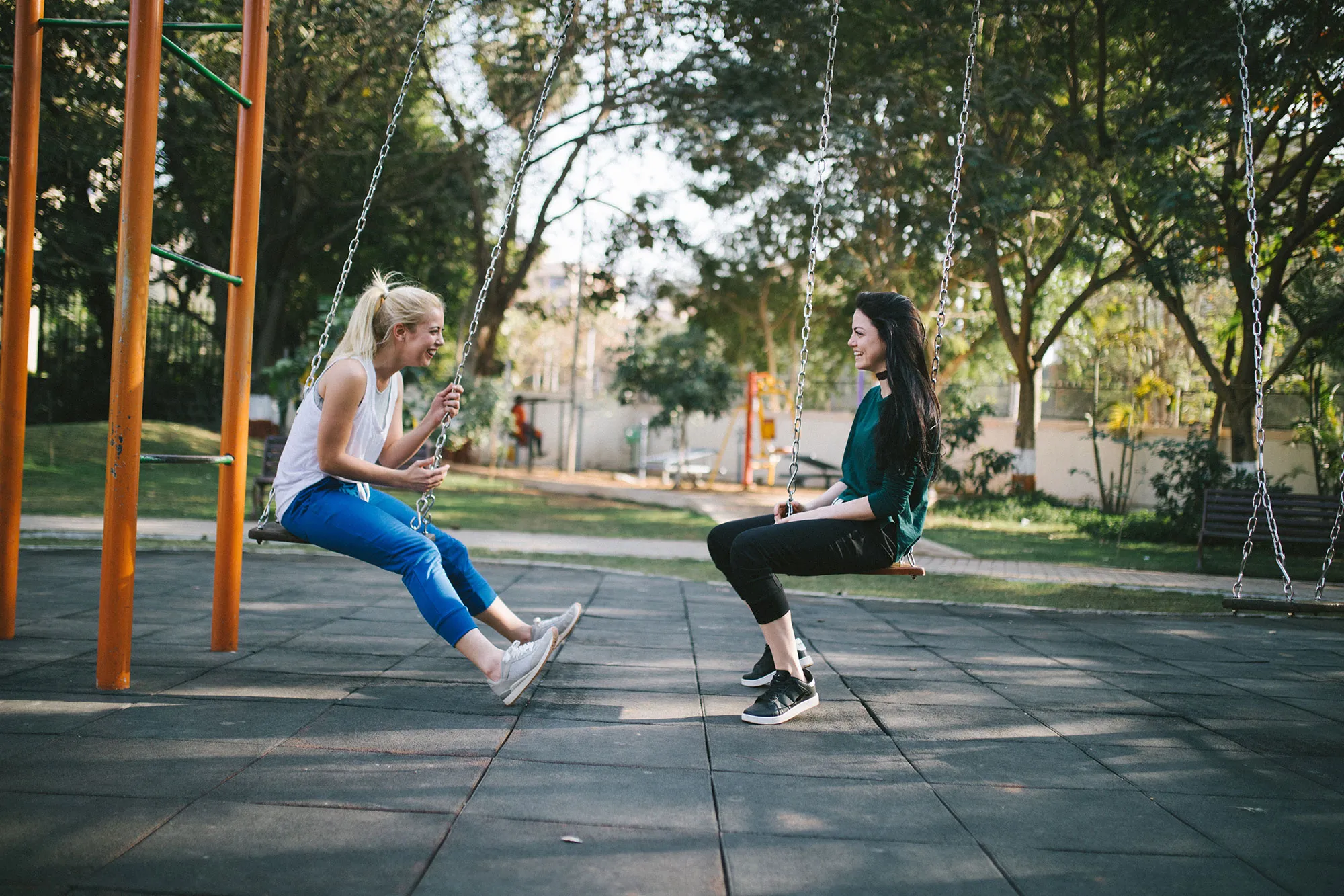 Quelle: Bewakoof.com Official / unsplash.com Zwei Frauen sitzen sich gegenüber auf zwei Schaukeln und unterhalten sich