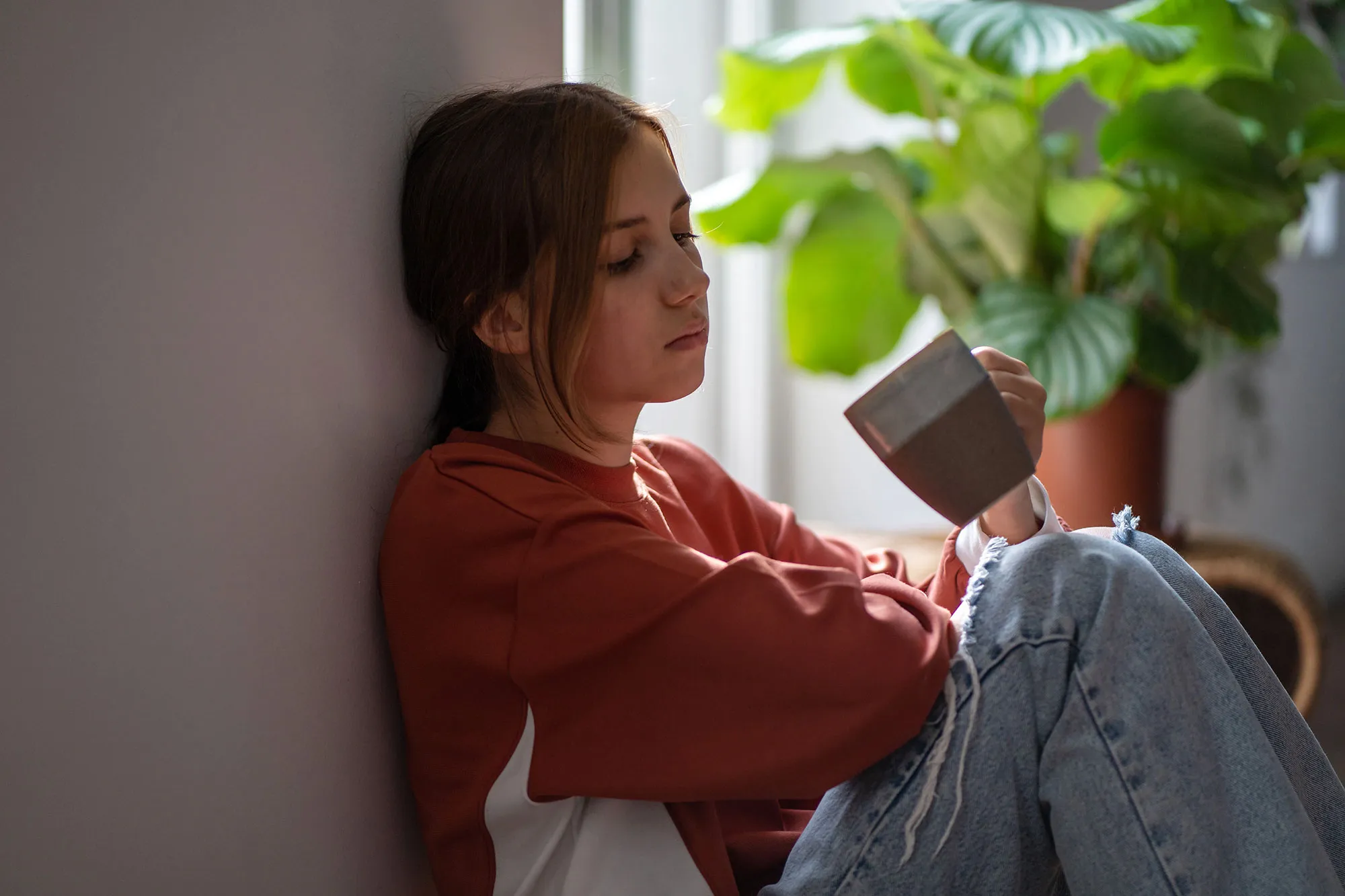 junge Frau nachdenklich mit Becher