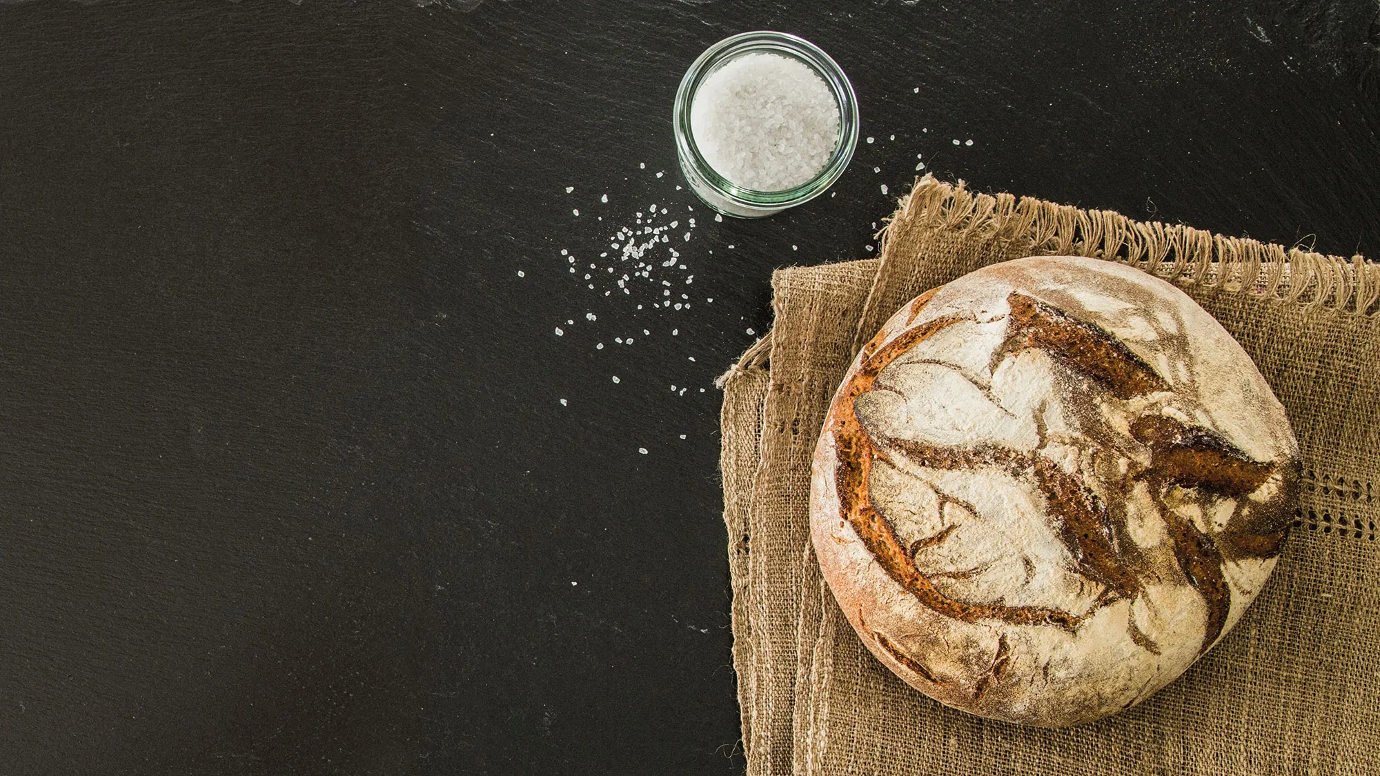 Ein Laib Brot neben einem Salzfässchen