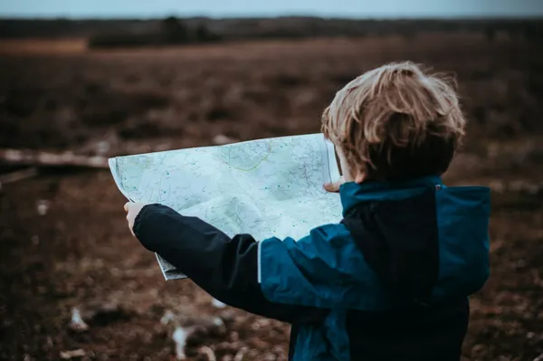 Quelle: Annie Spratt/Unsplash Kleiner Junge schaut auf Landkarte