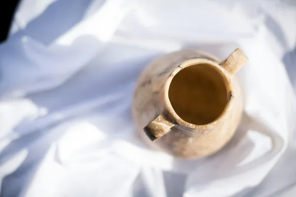 Quelle: Erin Randle/Unsplash Keramikgefäß auf weißem Tuch