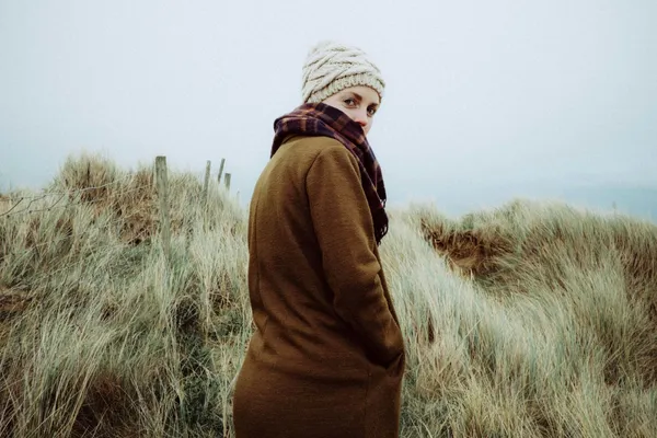 Quelle: Mitchell Orr/Unsplash Frau im hohen Gras und blick in die Kamera