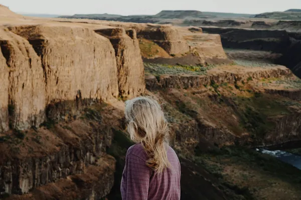 Quelle: Casey Callahan/Unsplash Frau steht gegenüber von Bergen und schaut in die Weite