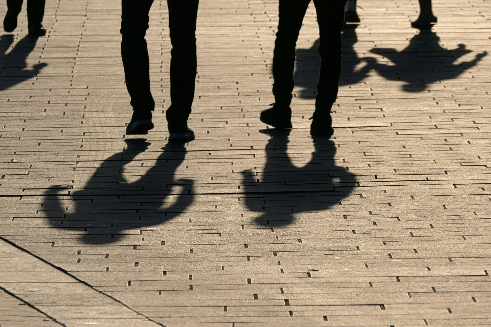 Silhouette von mehreren Menschen, die zu Fuß unterwegs sind