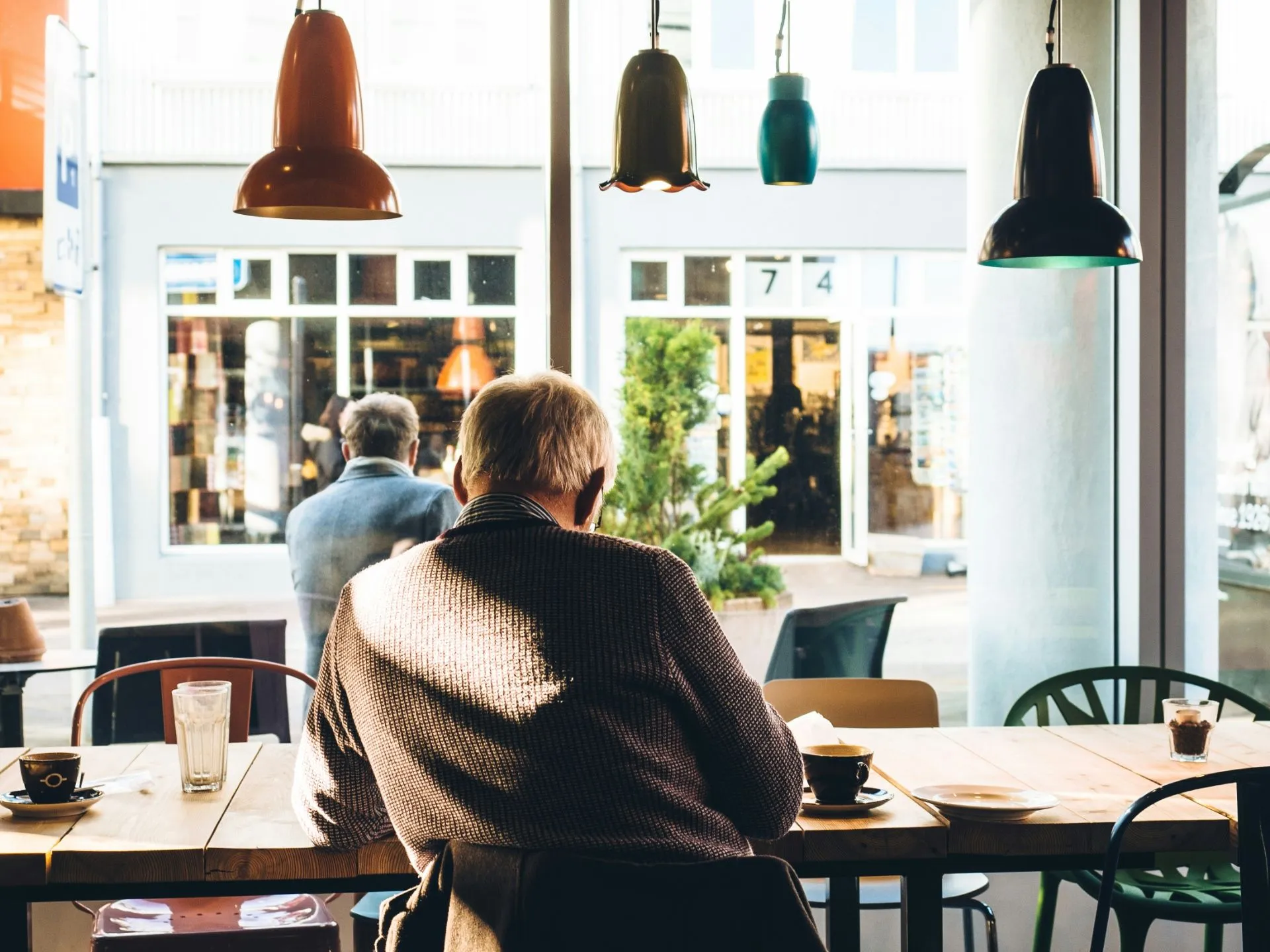 Mann sitzt im Café und schaut nach draußen