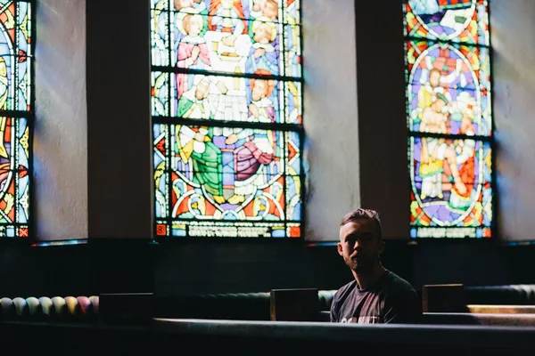 Quelle: Karl Fredrickson/Unsplash Mann sitzt in Kirchenbank