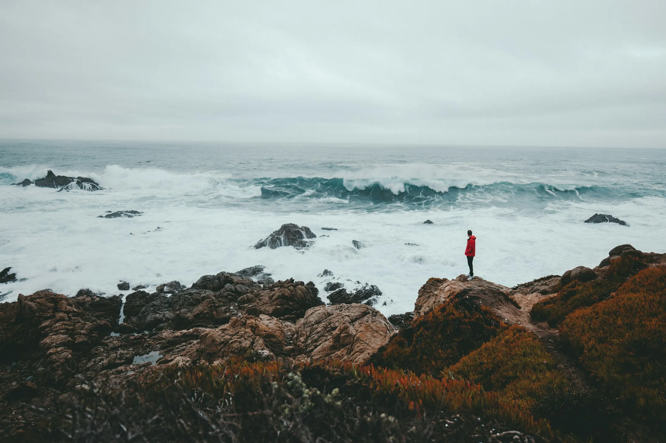 Quelle: Kyle Loftus/Unsplash Mann auf Felsformation vor Küste