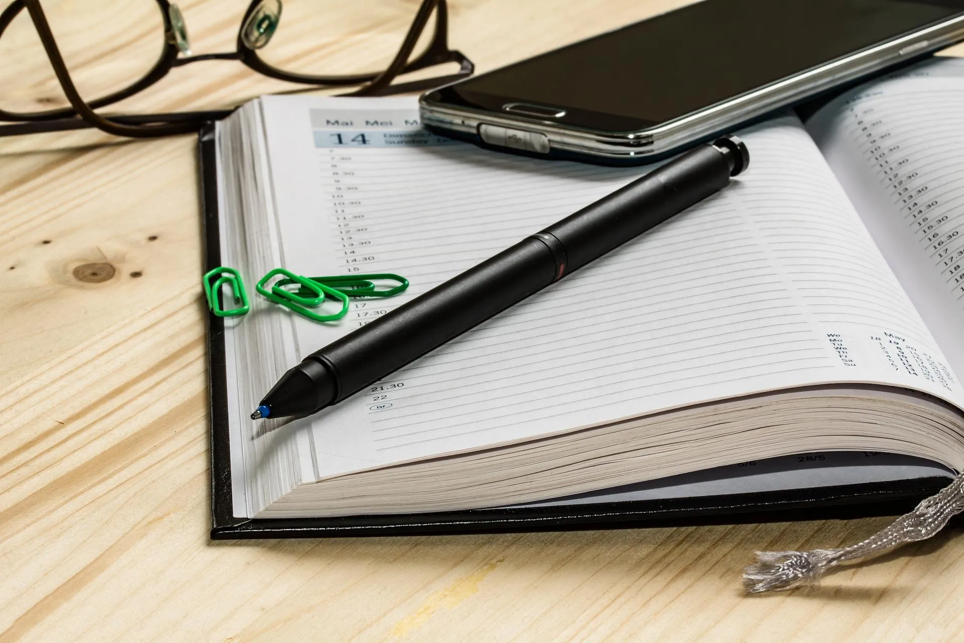 Kalnder mit Stift, Handy und Brille