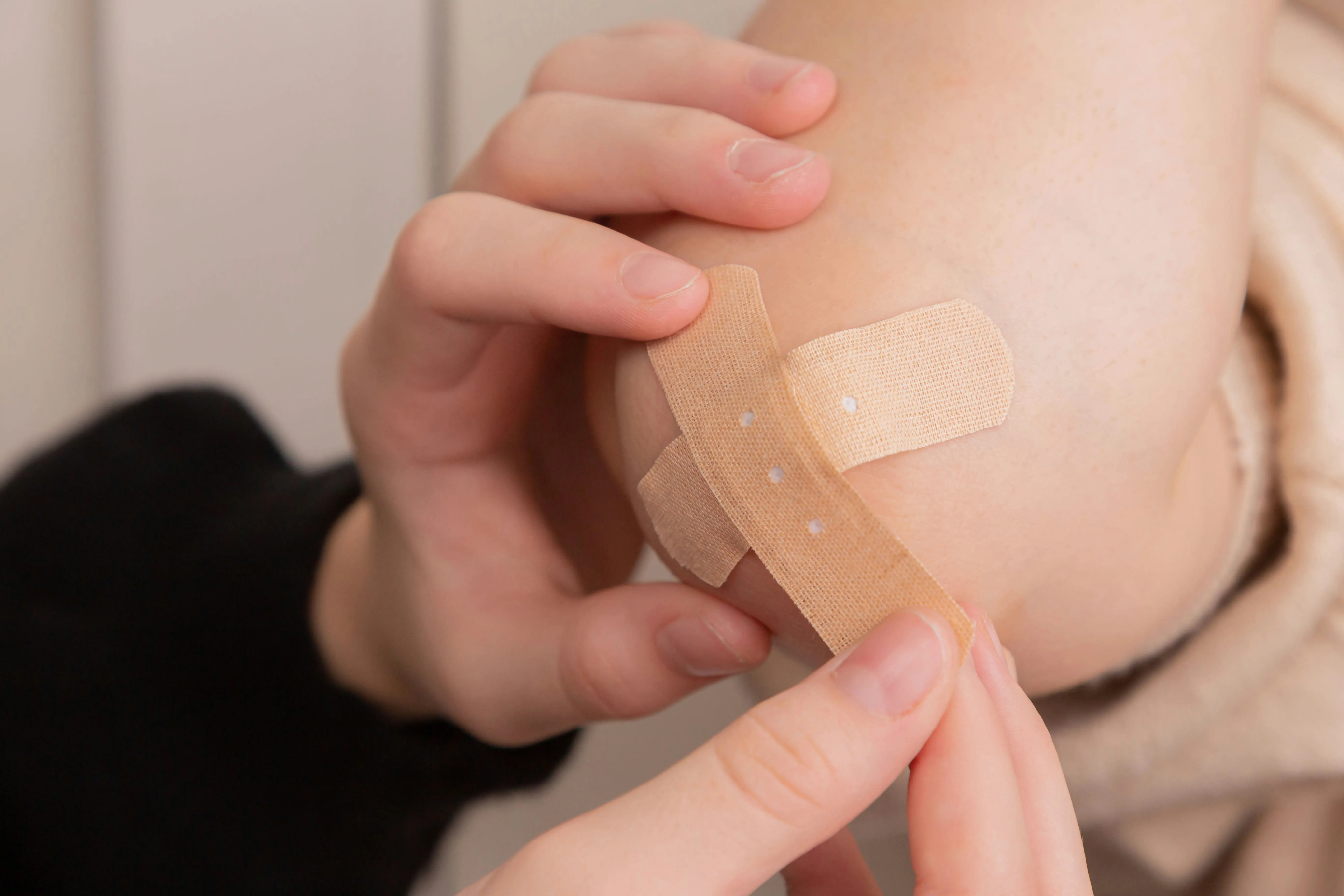 Pflaster wird auf Knie geklebt