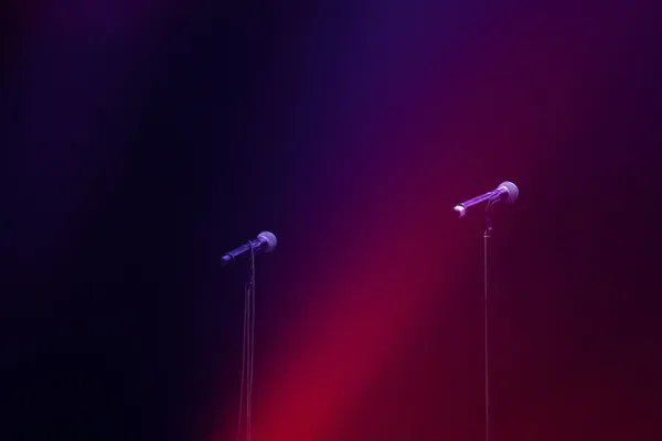 Quelle: Jake Hill/Unsplash Zwei Mikrofone stehen nebeneinander auf einer Bühne