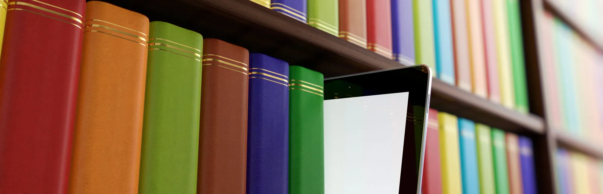 Regal einer Bibliothek mit Büchern und einem Tablet