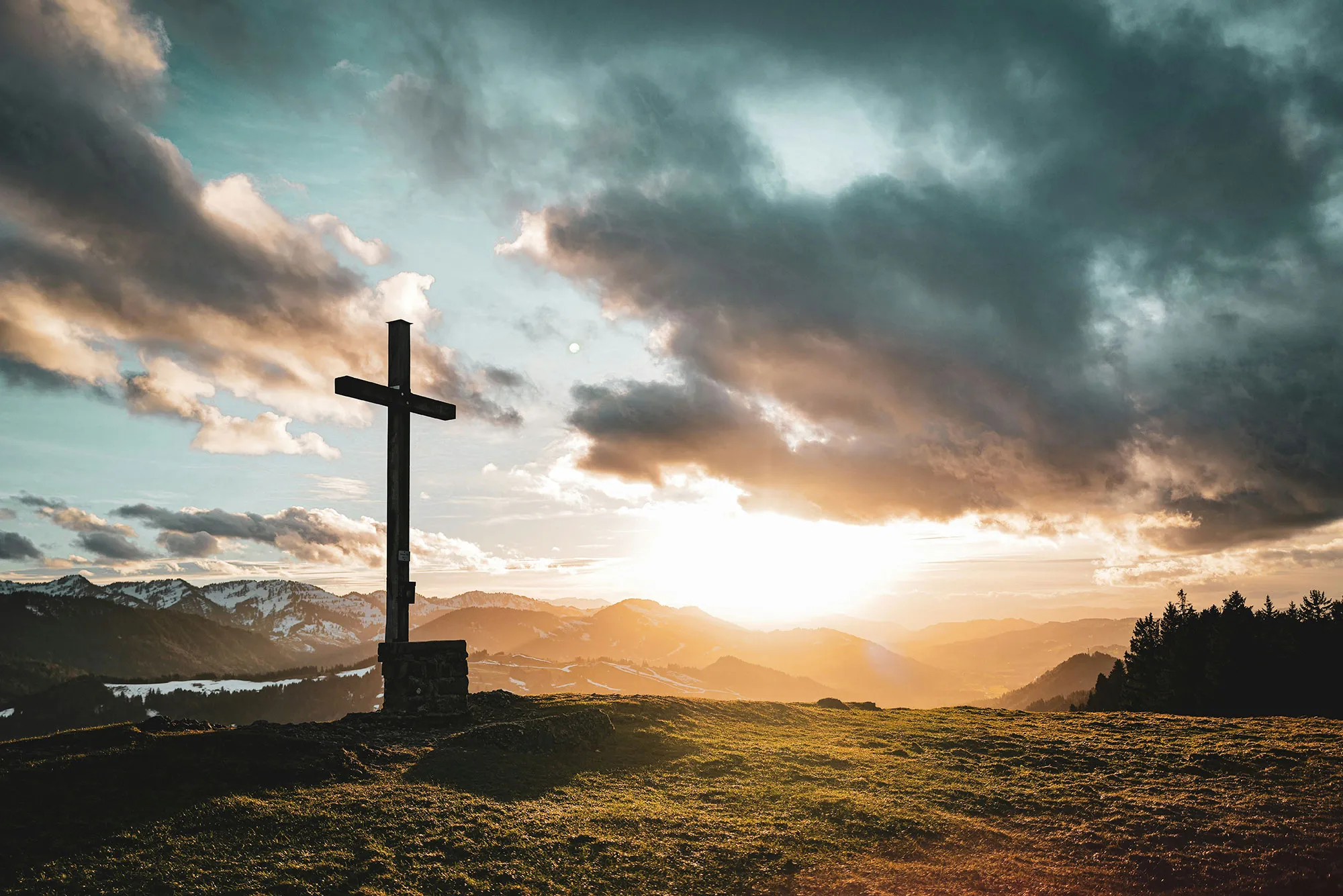 Ein Gipfelkreuz im Sonnenuntergang
