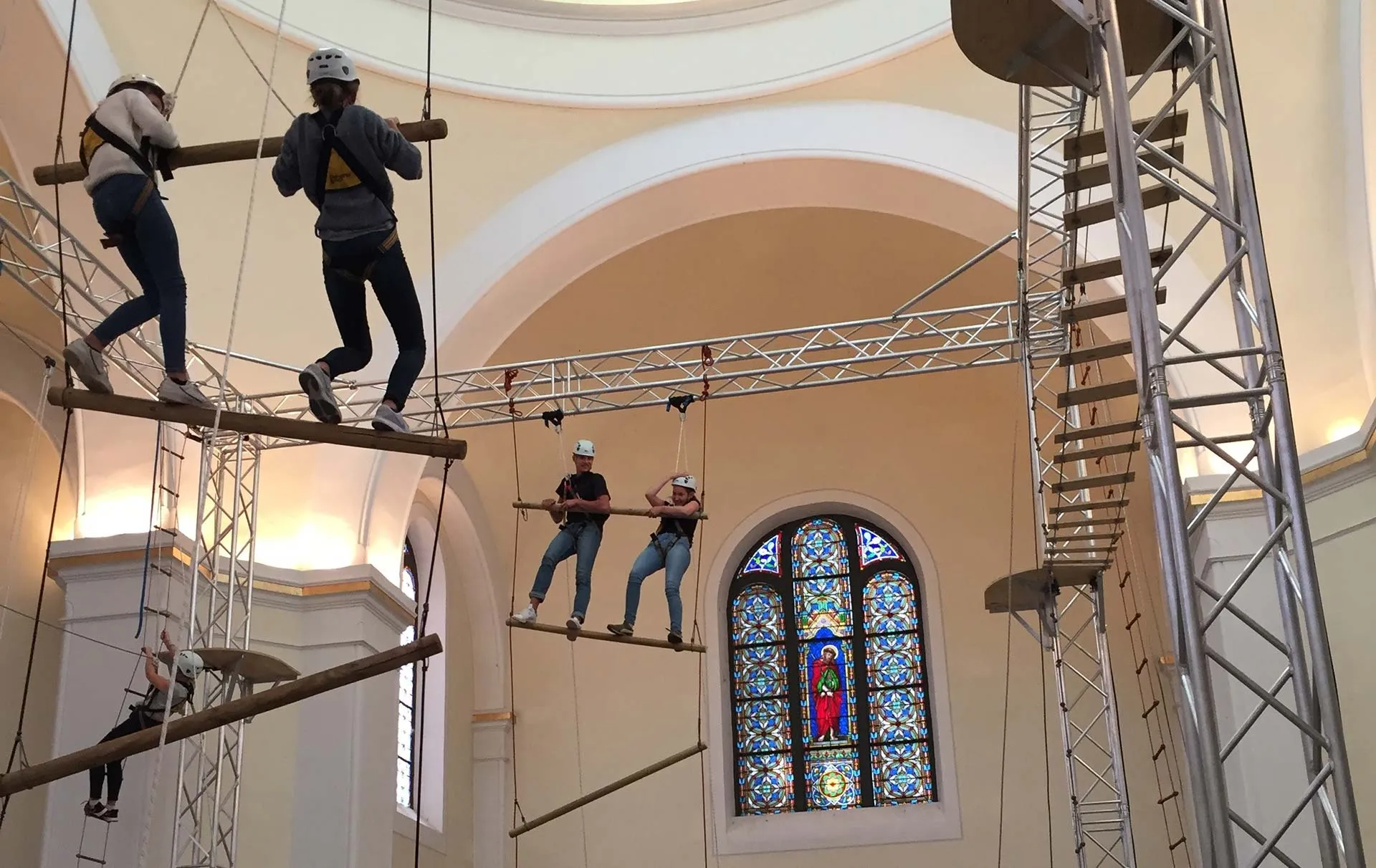 Jugendliche hängen in einem Klettergerüst, das in einer Kirche aufgebaut ist
