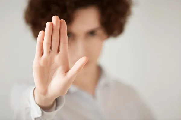 Eine Person macht eine Stopp-Geste mit ihrer Hand