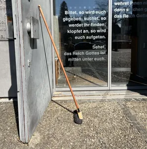 Ein Besen lehnt an der geöffneten Tür der Lukaskirche