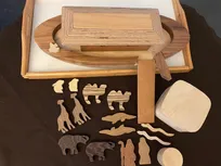 Godly Play Material zu der Flut und der Arche: Das Paket enthält 1 Arche Noah aus 4 Holzteilen (Arche, Leiter, Dach, Haus), 1 braunes Filztuch, 1 kleine Holzdose mit Taube, 1 Holzdose mit 6 x 2 Tieren und 2 Holzfiguren (Noah + Frau)