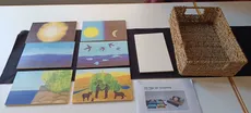 7 Holz-Bildtafeln mit Motiven der Schöpfungsgeschichte, schwarze Filz-Unterlage, ein Korb