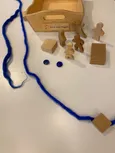 Godly Play Material zu Sara und Hagar bestehend aus einer offenen Holzkiste, drei Holzklötzen, zwei blauen Glassteinen, zwei blauen Wollfäden, fünf Holzfiguren