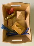Godly Play Material zu Mose. Enthält eine Holzpyramide, einen brennenden Dornbusch, eine Bundeslade mit 4 Tontafeln, ein goldenes Kalb aus Holz