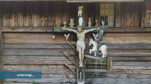 Holzgeschnitzte und bunt bemalte Kreusdarstellung an der Fassade des Hippenseppenhof im Schwarzwälder Freilichtmuseum Vogtsbauernhof in Gutach.