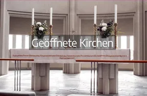 Heller Kirchenraum, im Vodergrund ein Altear mit rechts und links jeweils 2 Kerzen und einem Blumengesteck