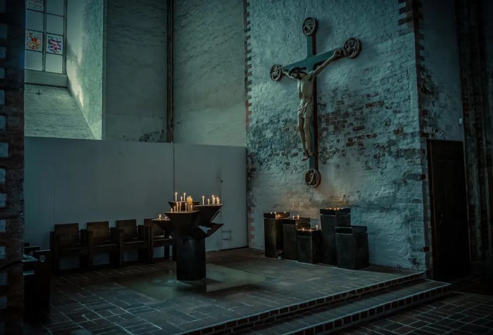 Quelle: Achim Scholty/Pixabay Innenraum einer Kirche mit Kerzen und Kreuz